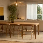 Salle à manger et salon dans la même pièce, séparation lumineuse avec tapis et canapé